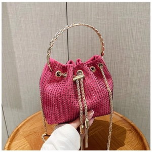 Détail du sac seau rose fuchsia avec strass, poignée dorée et cordon à pompons