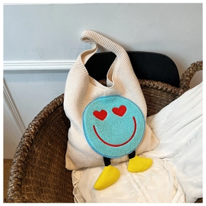 Λεπτομέρεια της πλεκτής τσάντας με μπλε smiley με καρδιές στα μάτια και 3D διακοσμητικά πόδια