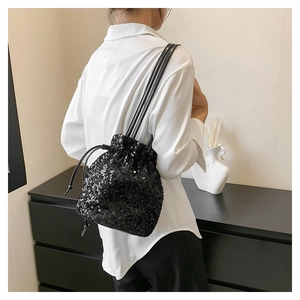 Détail du sac seau noir à paillettes avec fermeture à cordon et fine bandoulière réglable