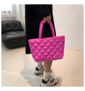 Detailed macro view of magenta quilted diamond pattern on water-resistant nylon tote