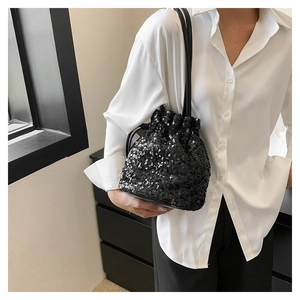 Détail du sac seau noir à paillettes avec fermeture à cordon et éclat métallique