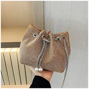 Détail du sac seau en strass avec fermeture par cordon et perles élégantes
