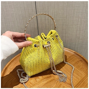 Détail macro du sac seau jaune vif de luxe avec strass et poignée en métal