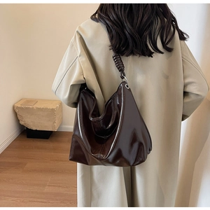 Close-up of the knot detail and glossy brown leather on this stylish large hobo bag