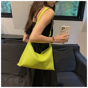 Vista dettagliata della borsa a secchiello verde neon in pelle opaca a grana litchi
