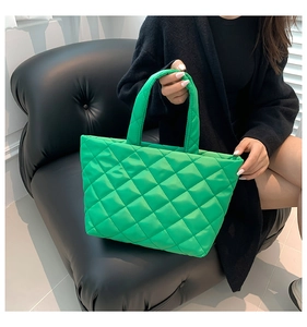 Detail of bright green tote bag featuring classic diamond quilted stitching on fabric