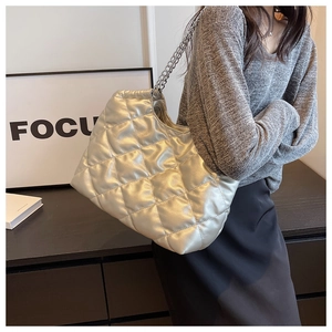 Detail view of silver quilted chain bag with metallic texture and sleek finish