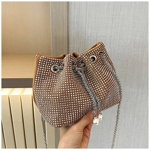Détail du sac seau en strass avec cordon en chaîne argentée et pendentif en perle