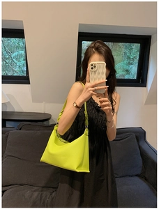 Dettaglio di una borsa a secchiello verde neon in ecopelle con tracolla dal design a spirale