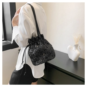 Détail du sac seau à paillettes noires avec cordon de serrage et bandoulière en cuir