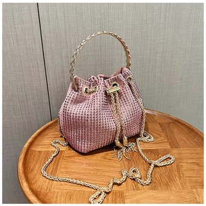 Détail du sac seau rose en strass avec poignée dorée et bandoulière en chaîne dorée