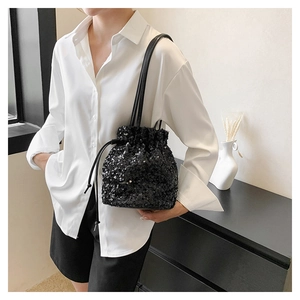 Vue détaillée du sac seau noir à paillettes avec cordon de serrage sur mannequin