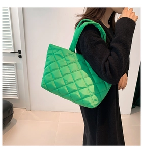 Detailed view of green quilted tote bag with diamond stitching and soft padded texture