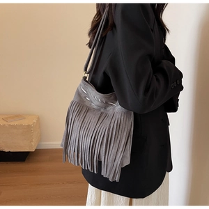 Détail du sac seau en daim gris avec broderie ethnique et longues franges fluides
