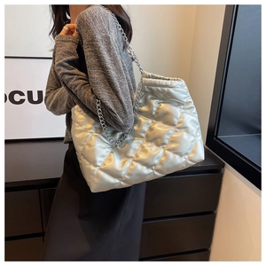 Detailed view of silver quilted tote bag featuring metallic finish and thick chain strap