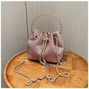 Détail du sac seau rose en strass avec poignée en anneau doré et cordon à glands