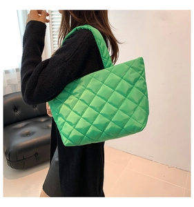 Close-up of bright green quilted tote bag featuring a diamond stitched pattern and nylon texture