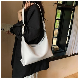 Dettaglio borsa a mezzaluna bianca con tracolla intrecciata e cerniera in metallo lucido