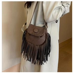 Detailed view of dark brown suede saddle bag with handmade stitching and long fringe