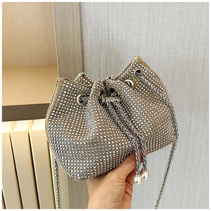 Détail du sac seau avec strass brillants, cordon de serrage et pompons de perles
