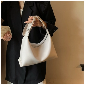 Dettaglio della borsa a mezzaluna in pelle bianca con manico intrecciato e zip argentata