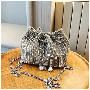 Gros plan du sac seau en strass argentés avec cordon de serrage et breloques en perles