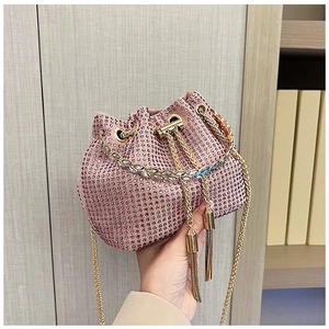 Détail du sac seau en strass rose avec anse en chaîne dorée et glands décoratifs