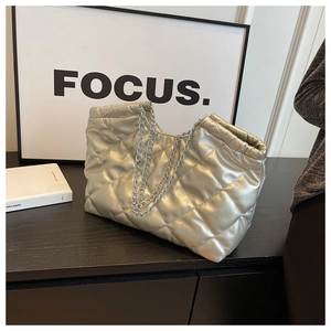 Close-up of quilted champagne silver tote bag with metal chain strap and metallic finish
