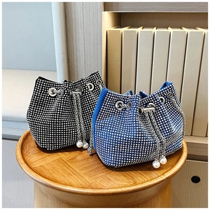 Détail de sacs seaux en strass bleus et noirs avec chaînes en métal et perles pendantes