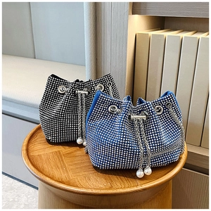 Détail de sacs seaux en strass avec cordons en chaîne et pendentifs en perles