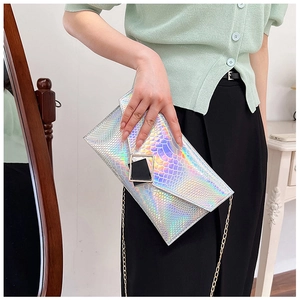 Dettaglio pochette olografica argento con trama a serpente e catena dorata