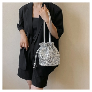 Détail du sac seau à paillettes argentées avec cordon de serrage et bandoulière chaîne
