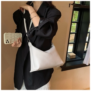 Dettaglio della borsa tote in pelle bianca con trama litchi e fibbie in metallo argentato