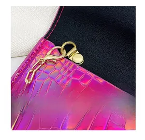 Close-up of pink crocodile texture bag featuring gold metal hook and link chain detail