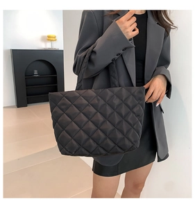 Detail shot of a black quilted tote bag with a modern diamond pattern for women