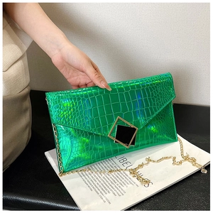 Detail of green holographic crocodile pattern envelope bag with gold chain and square buckle