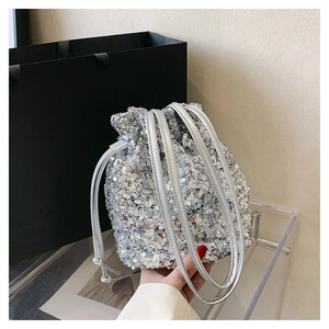 Vue détaillée du sac seau à paillettes argentées avec fermeture à cordon et fines chaînes