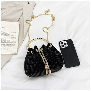 Détail du sac seau en strass noirs avec poignée dorée et cordon de serrage à glands