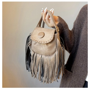 Detailed close-up of khaki suede saddle bag featuring bohemian fringe and woven edges