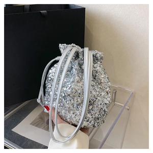 Gros plan du sac seau à paillettes argentées avec cordon de serrage et effet brillant