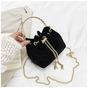 Détail du sac seau noir en strass avec chaîne dorée et cordon de serrage à glands