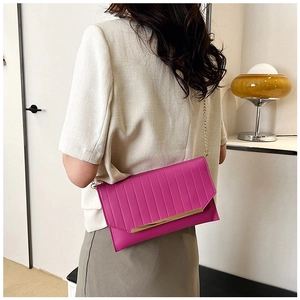 Detailansicht einer pinkfarbenen gesteppten Umschlagtasche mit Goldleiste und Kette