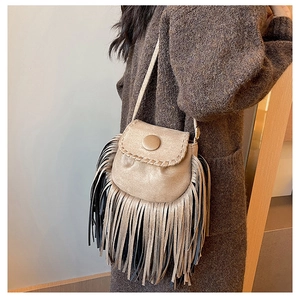 Detail showing bohemian suede saddle bag with long tassels and stitching on a model