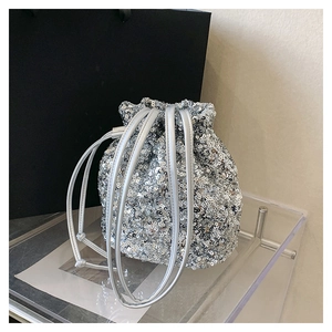 Gros plan détaillé d'un sac seau à paillettes argentées avec fermeture à cordon et éclat