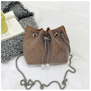 Détail du sac seau en strass avec fermeture à cordon, chaîne en métal et perles