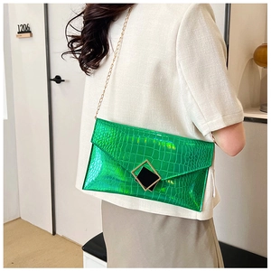 Detail of green laser crocodile texture envelope clutch with gold chain strap