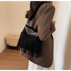 Détail de la broderie plume et des longues franges sur le sac seau en daim noir