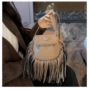 Detail showing vintage suede bucket bag with long tassels and hand-stitched weaving details