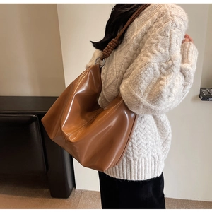 Caramel brown large hobo shoulder bag featuring knotted strap and silver metal rings