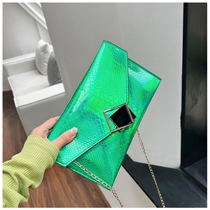 Dettaglio della pochette a busta verde neon con trama coccodrillo metallizzata e oro